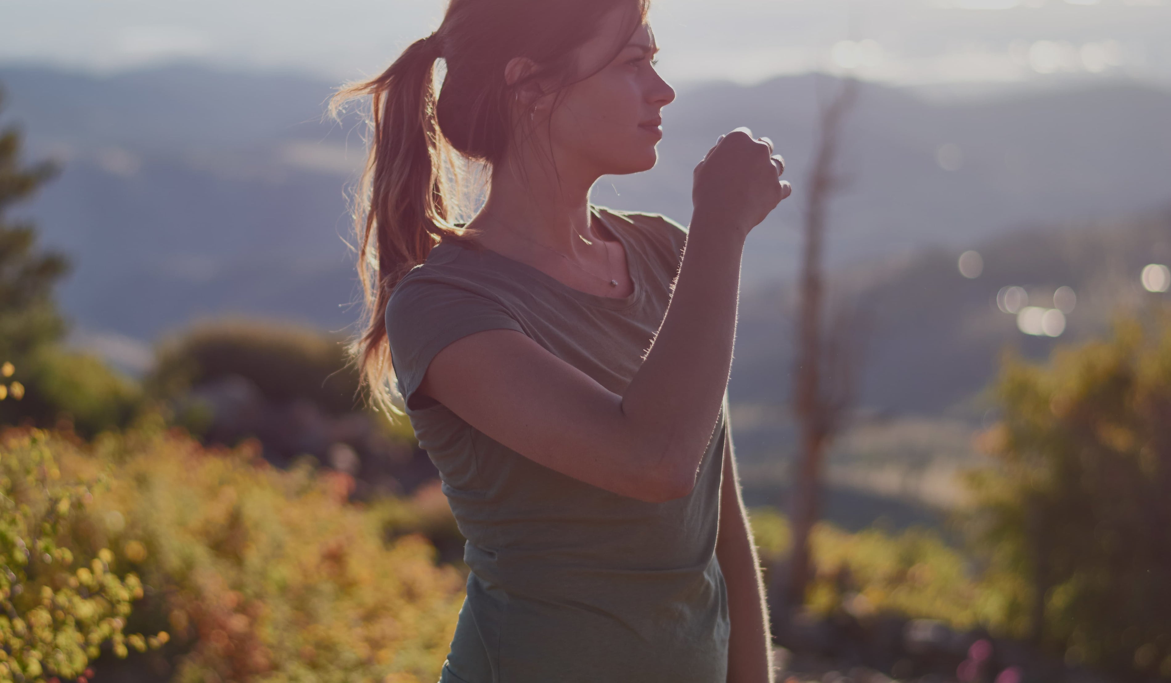 Woman wearing an ONNO hemp t-shirt in a field at golden hour