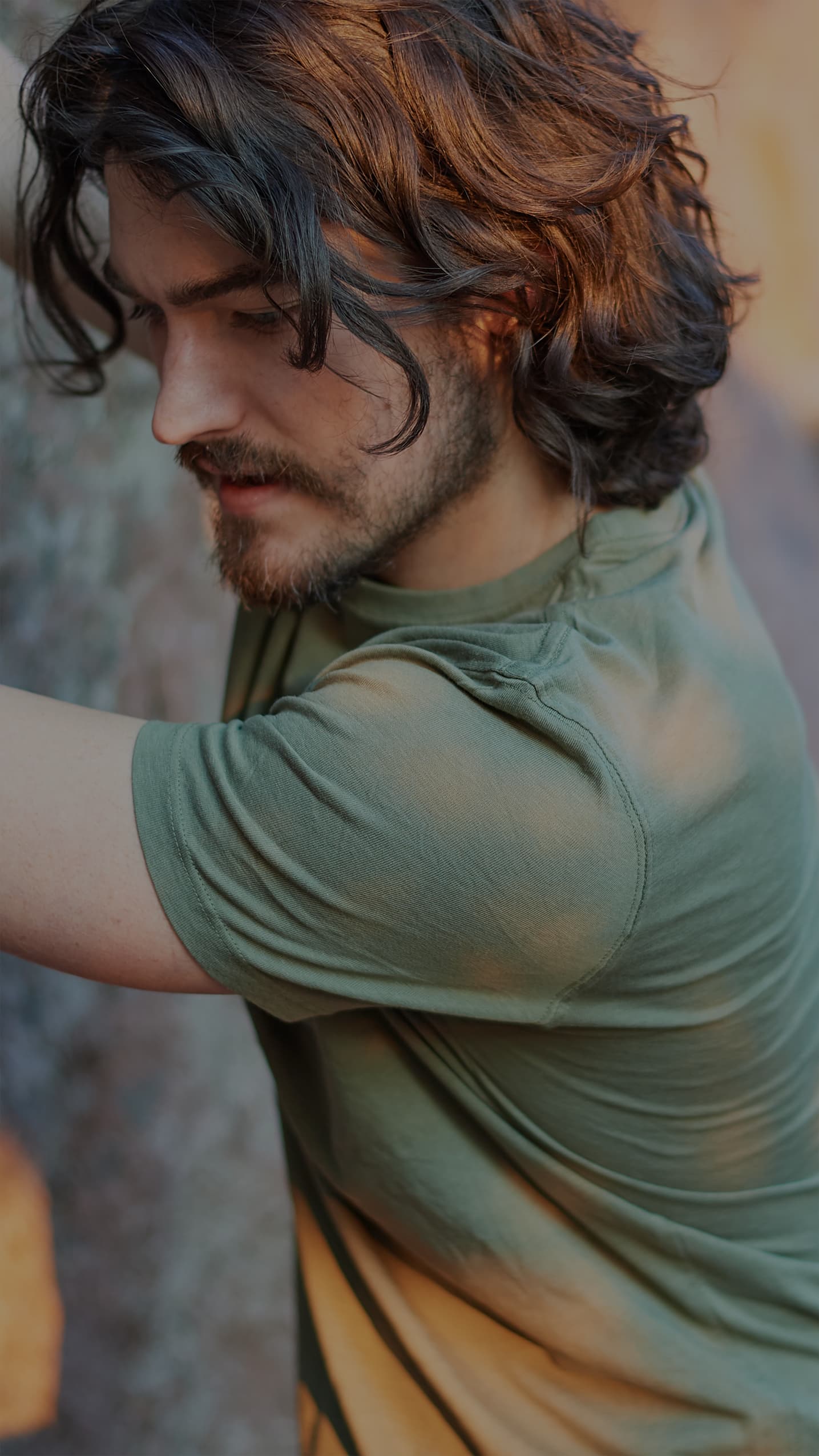 Man wearing a green ONNO organic cotton t-shirt while rock climbing