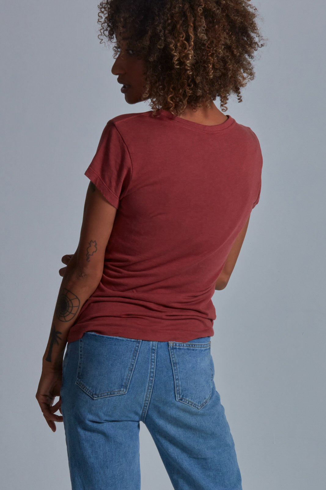 ONNO bamboo t-shirt in Brick Unpatched, Sage is 5'7" and wearing size XS.