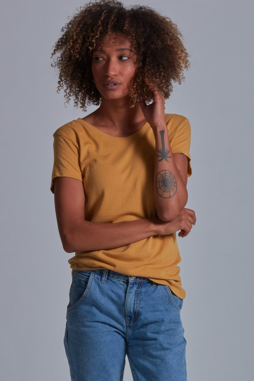 ONNO bamboo t-shirt in Mustard Unpatched, Sage is 5'7" and wearing size XS.