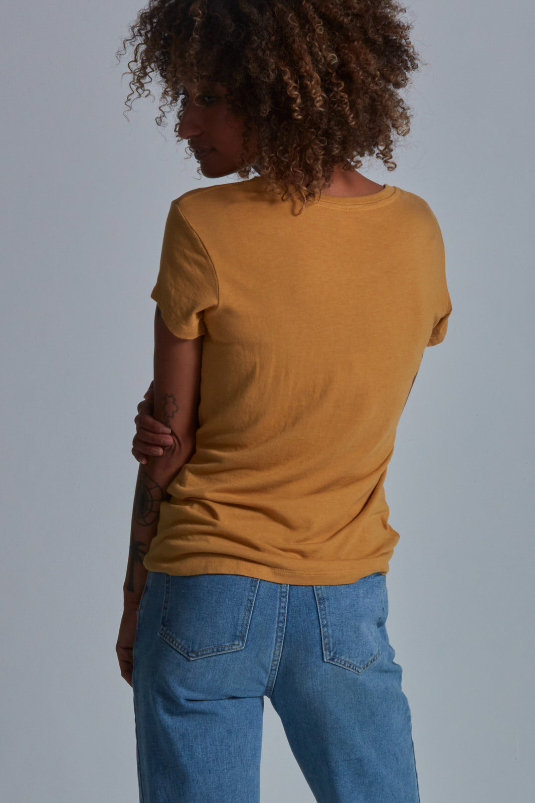 ONNO bamboo t-shirt in Mustard Unpatched, Sage is 5'7" and wearing size XS.