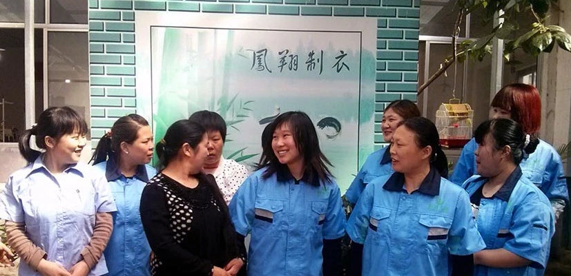 Group of employees in blue uniforms standing in front of a building with Chinese text.